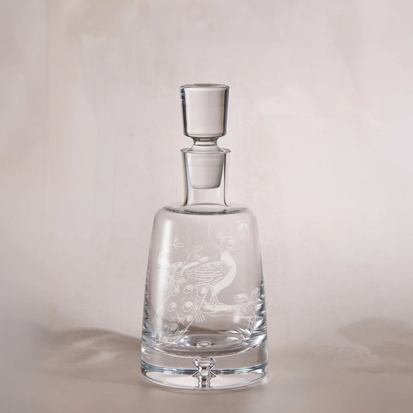 Clear glass decanter with engraved childs drawing a light background
