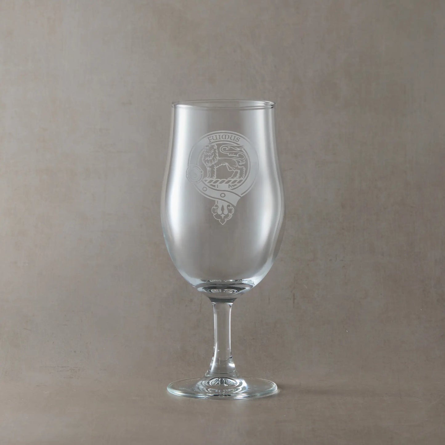 Engraved stemmed beer glass with an illustration of a Scottish clan crest with belt and buckle