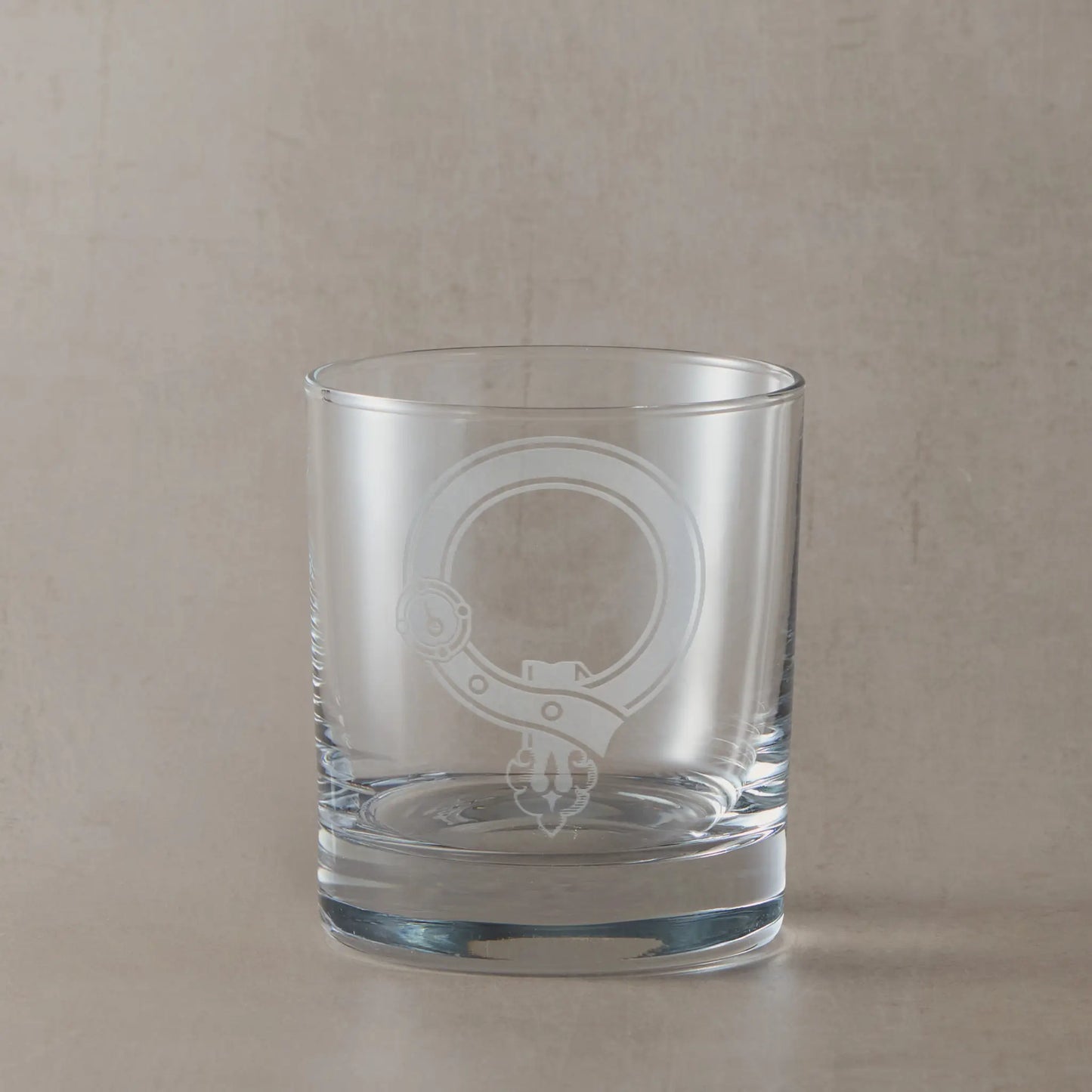 Engraved whisky glass featuring a Scottish clan crest with belt and buckle motif, centre left blank for your own design