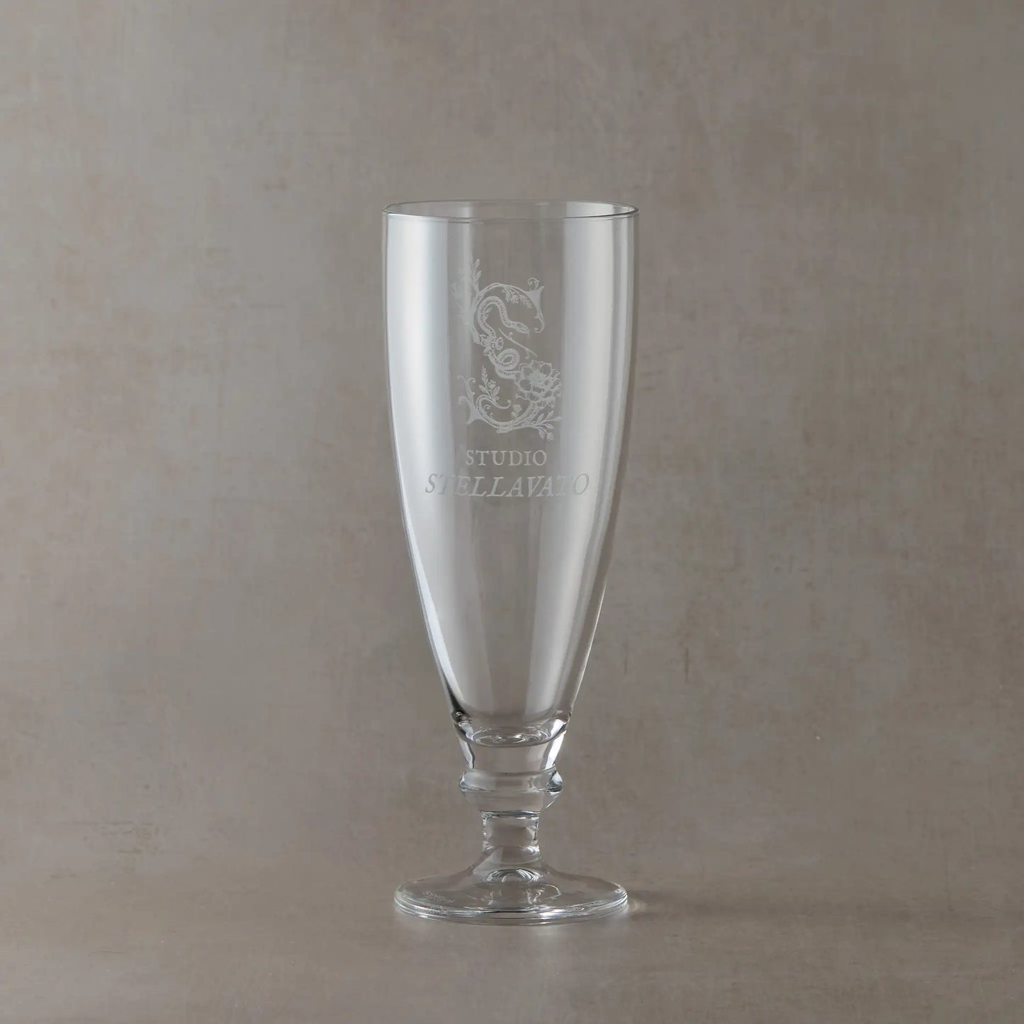 Custom corporate tapered stemmed beer glass engraved with business logo, shown on a neutral background