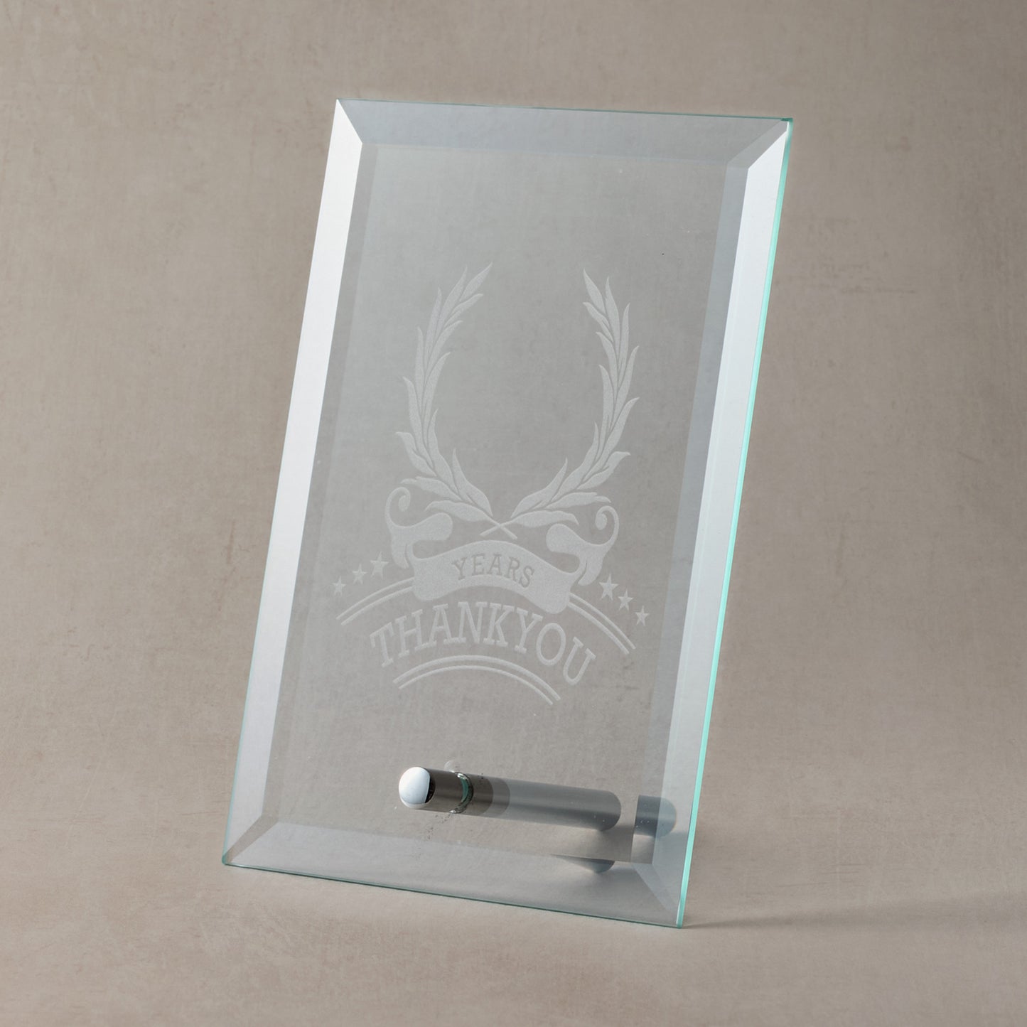 Glass plaque with engraved laurel wreath and thankyou design and text on a beige background
