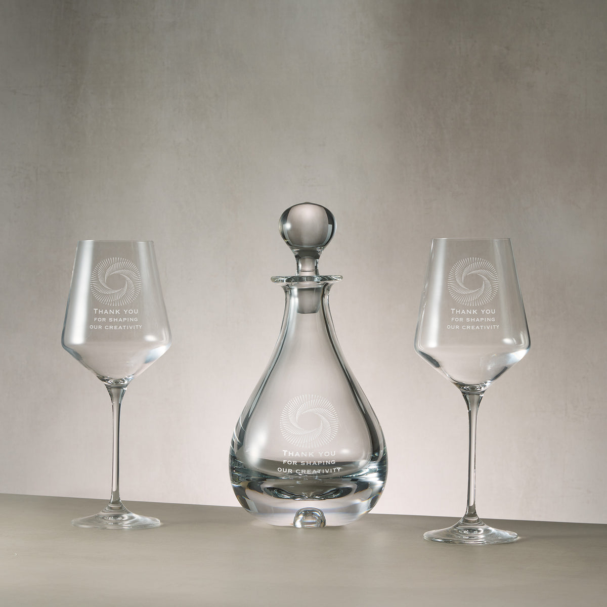 Engraved wine decanter and matching pair of wine glasses featuring bespoke corporate logo engraving.