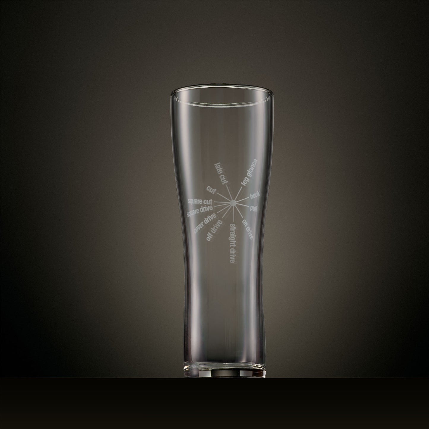Engraved pint glass featuring a radial typography design of classic cricket batting strokes.
