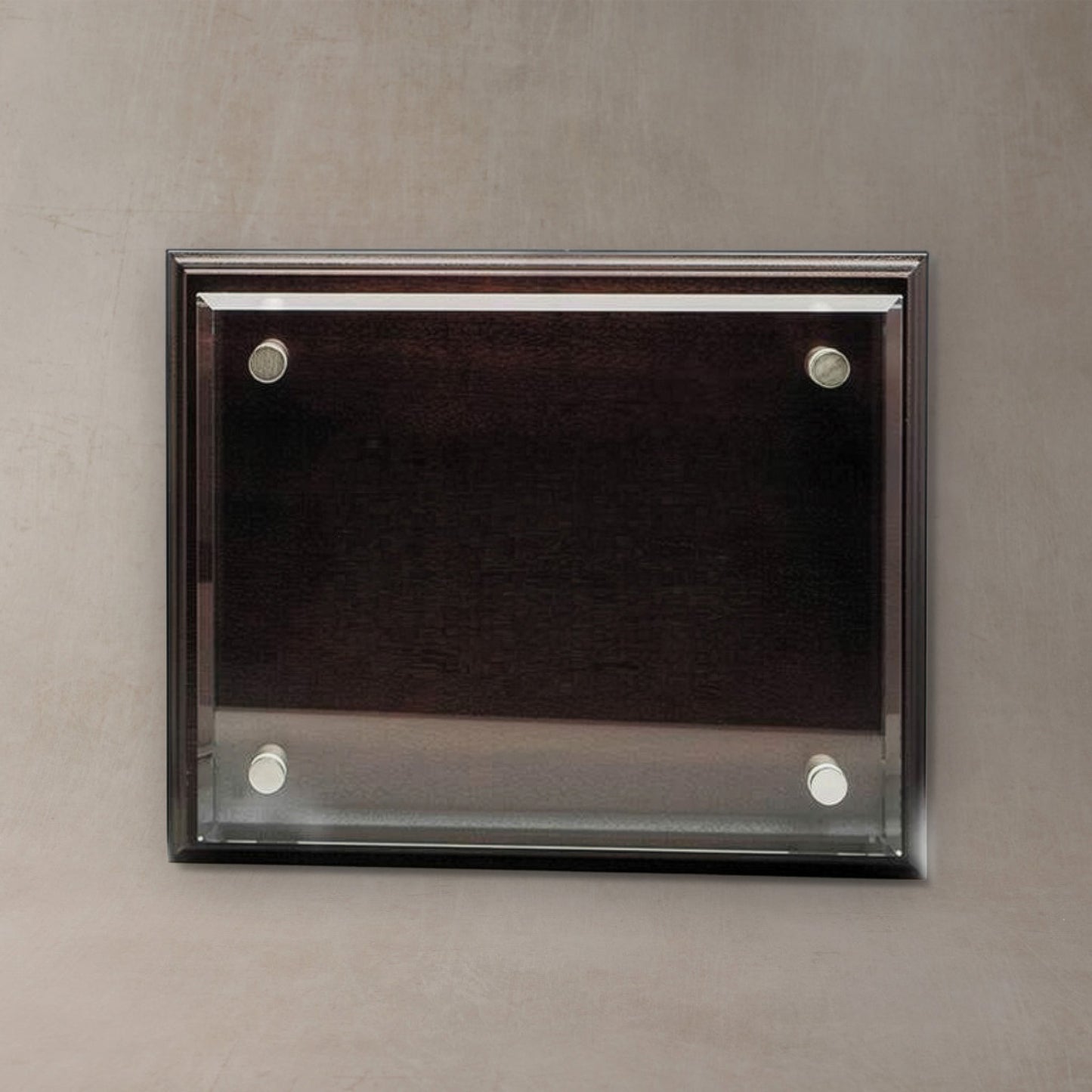 A rectangular wall-mounted display plaque with a dark wood frame and four silver wall anchors, shown against a textured gray wall.