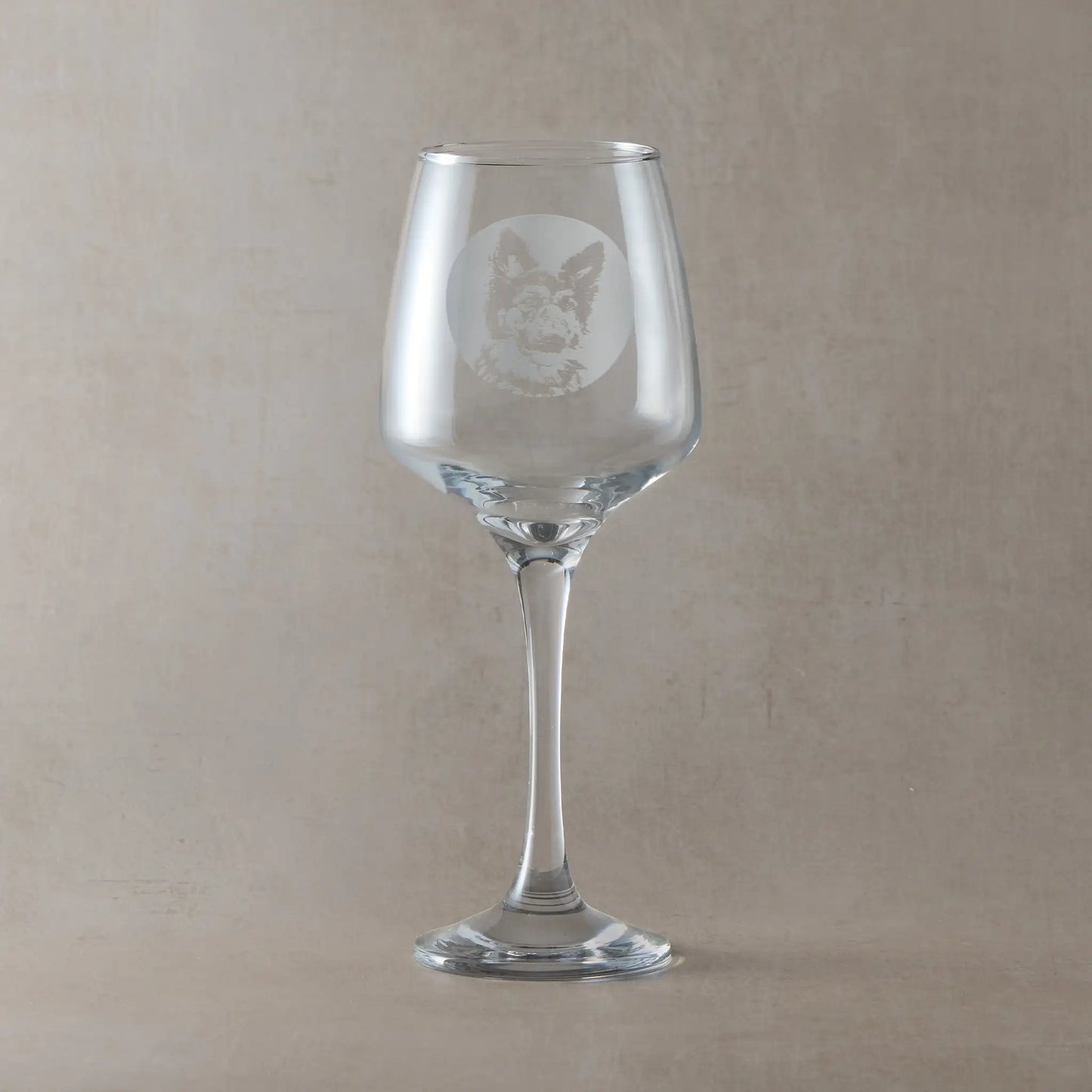 Wine glass engraved with a portrait of a German Shepherd shown against a beige background.
