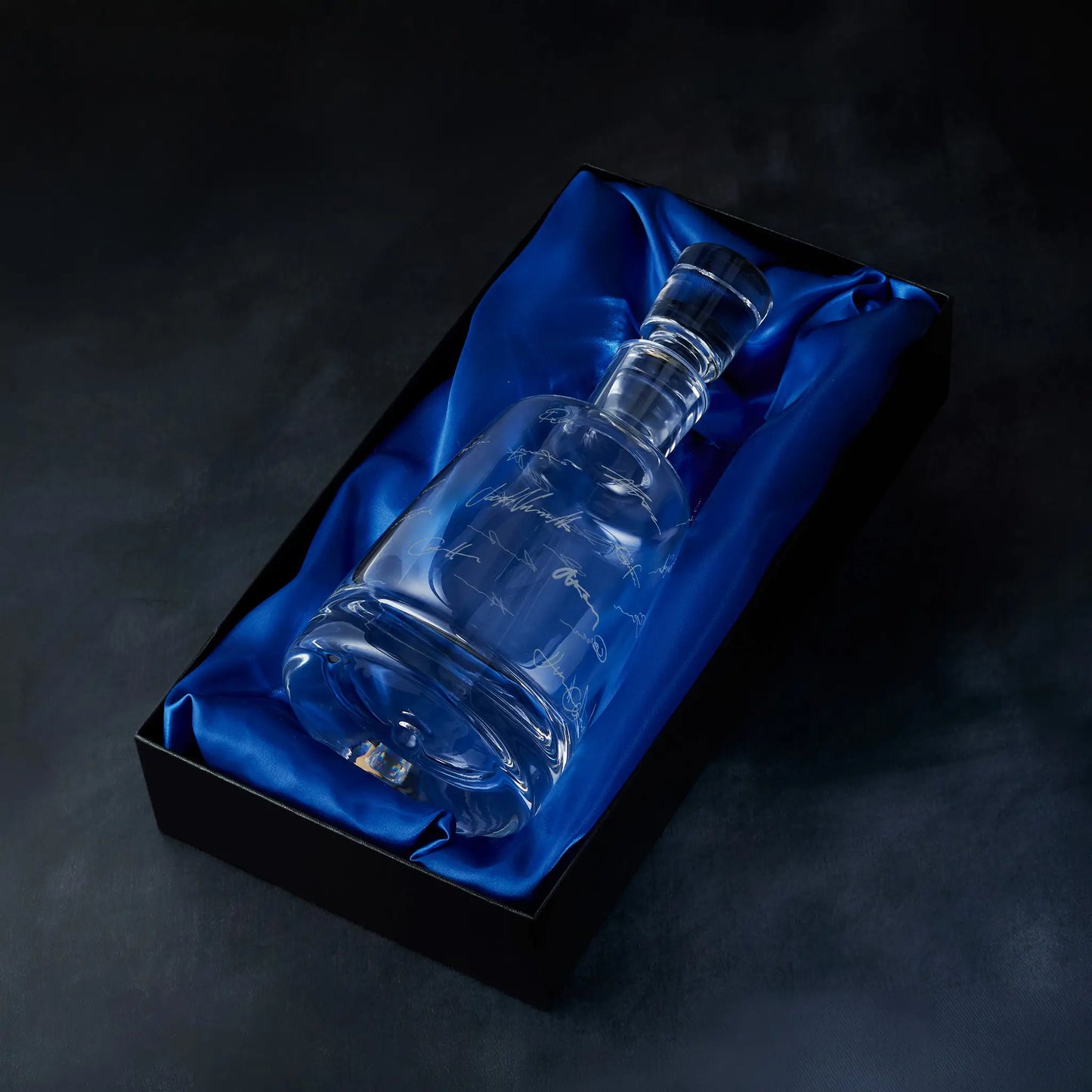 Engraved handritten signatures decanter presented in a satin-lined gift box, photographed on deep blue background