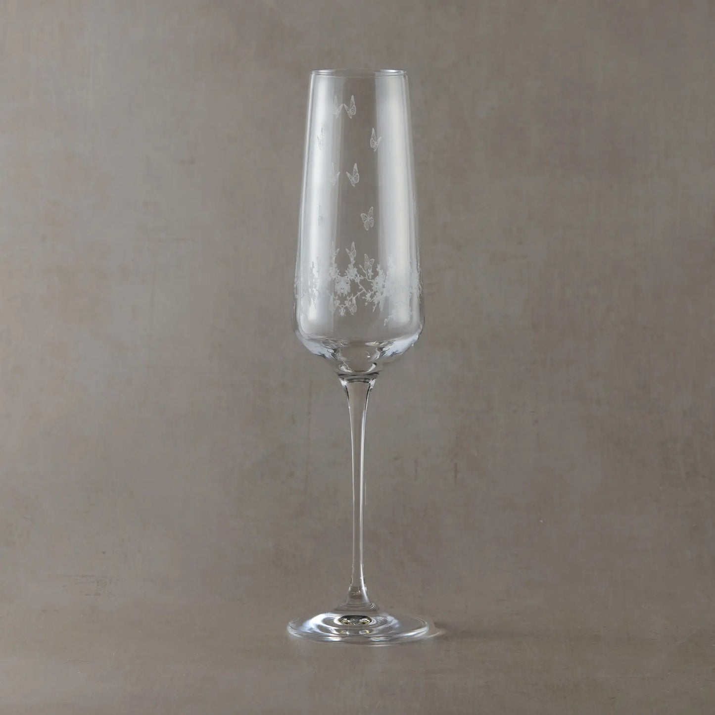 Engraved champagne flute featuring a wraparound floral garland, butterflies and garden birds.