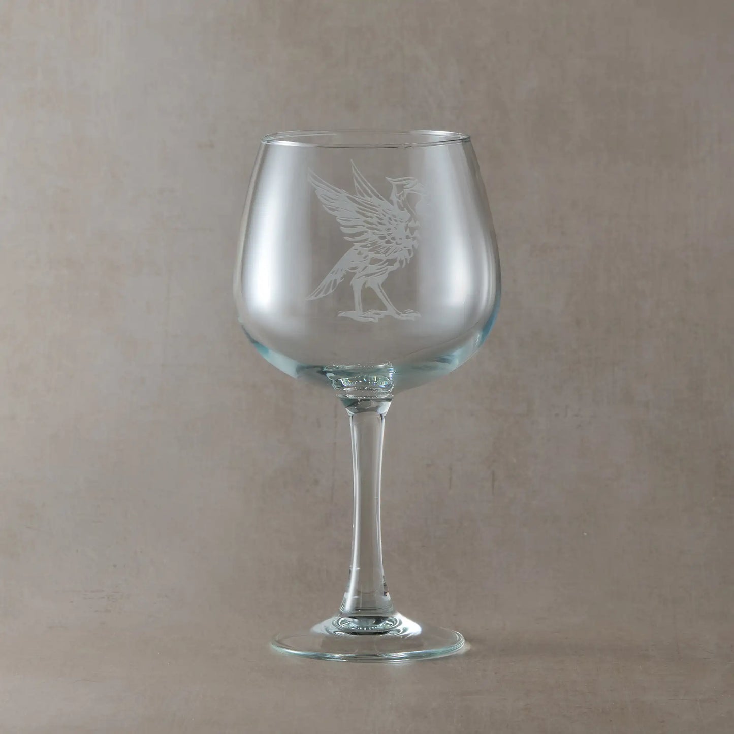 Gin glass engraved with a Liverbird facing right, photographed on a light background