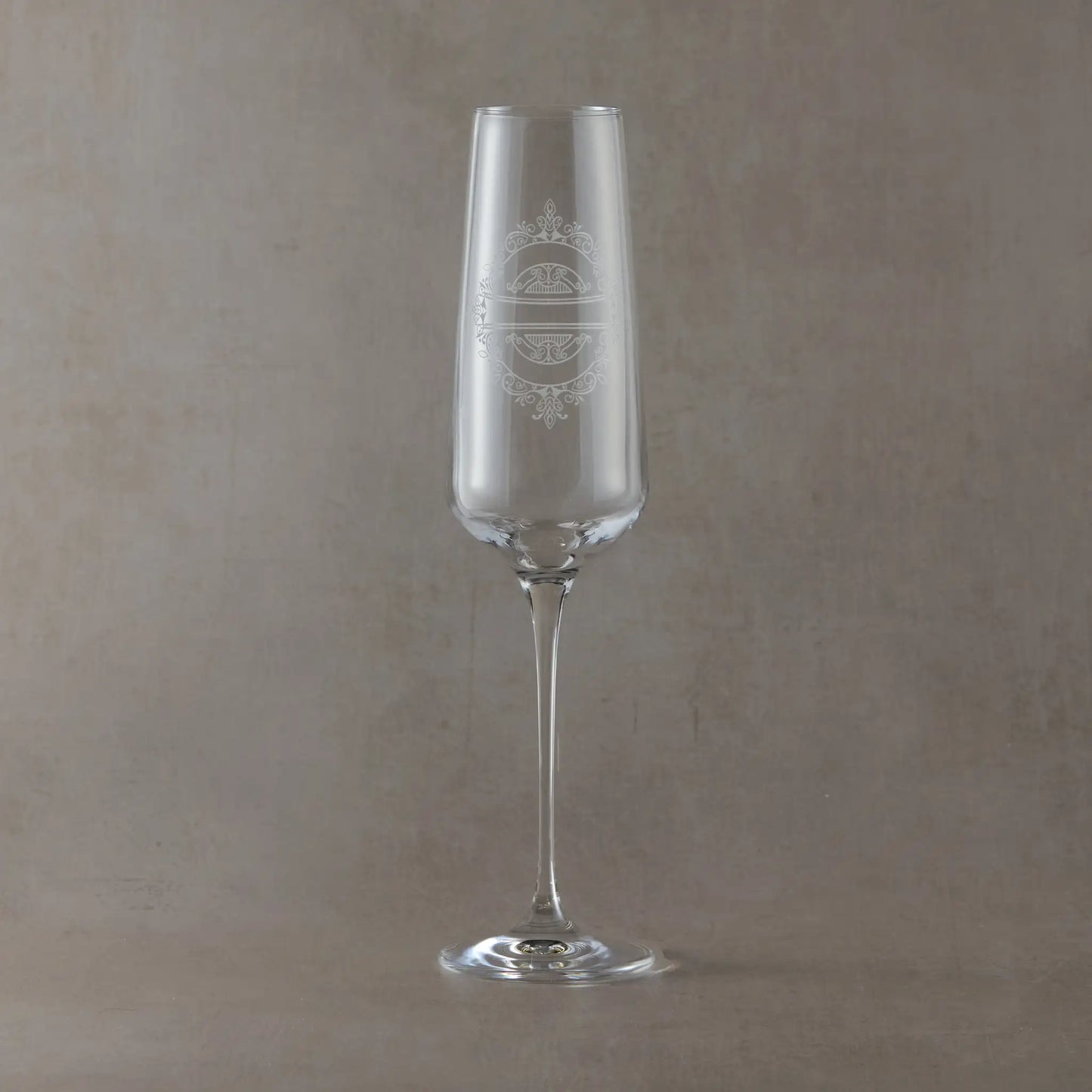 Engraved wedding party champagne flute with a venetian lace design on a pale background