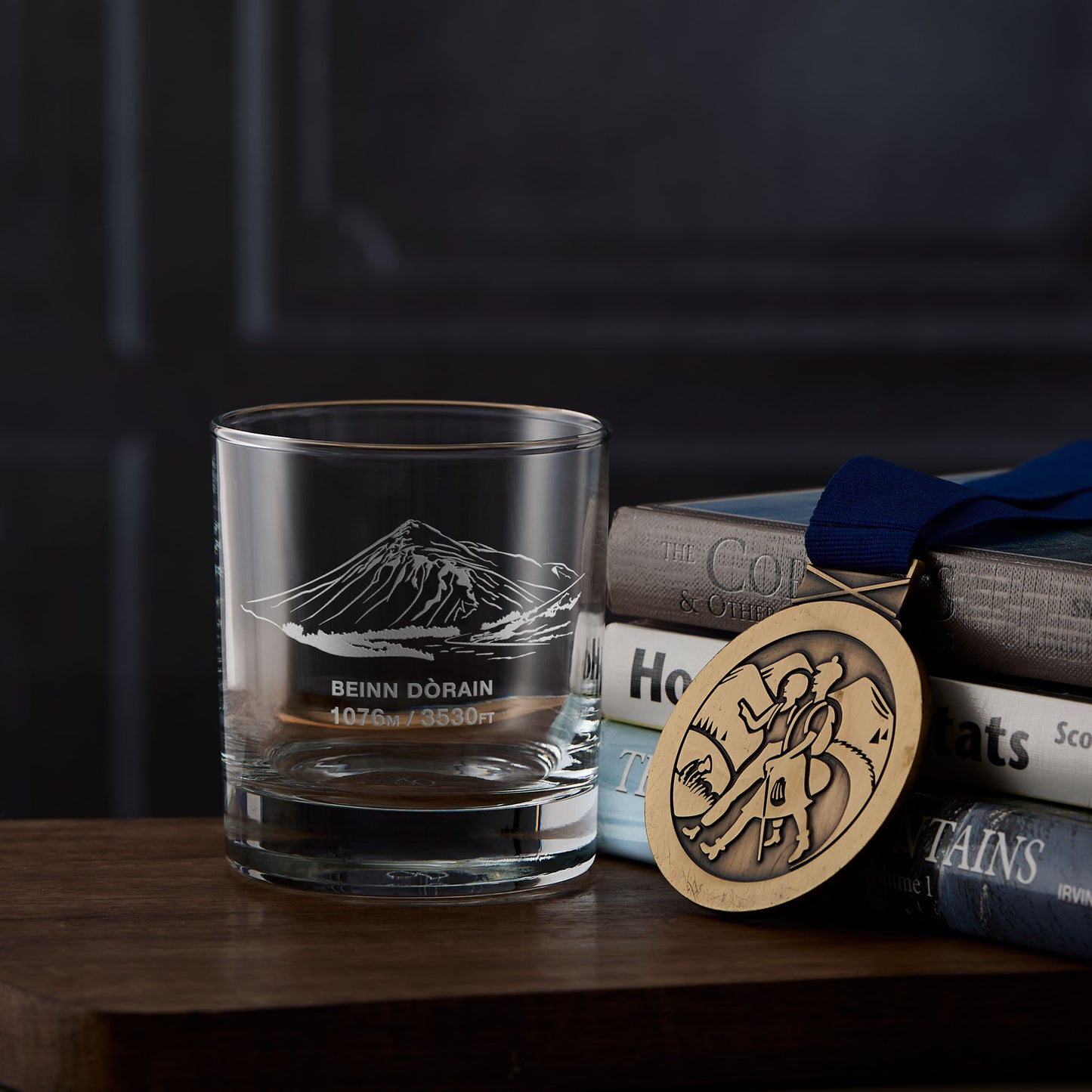 Whisky glass engraved with Beinn Dorain, photographed on a stack of hillwalking books