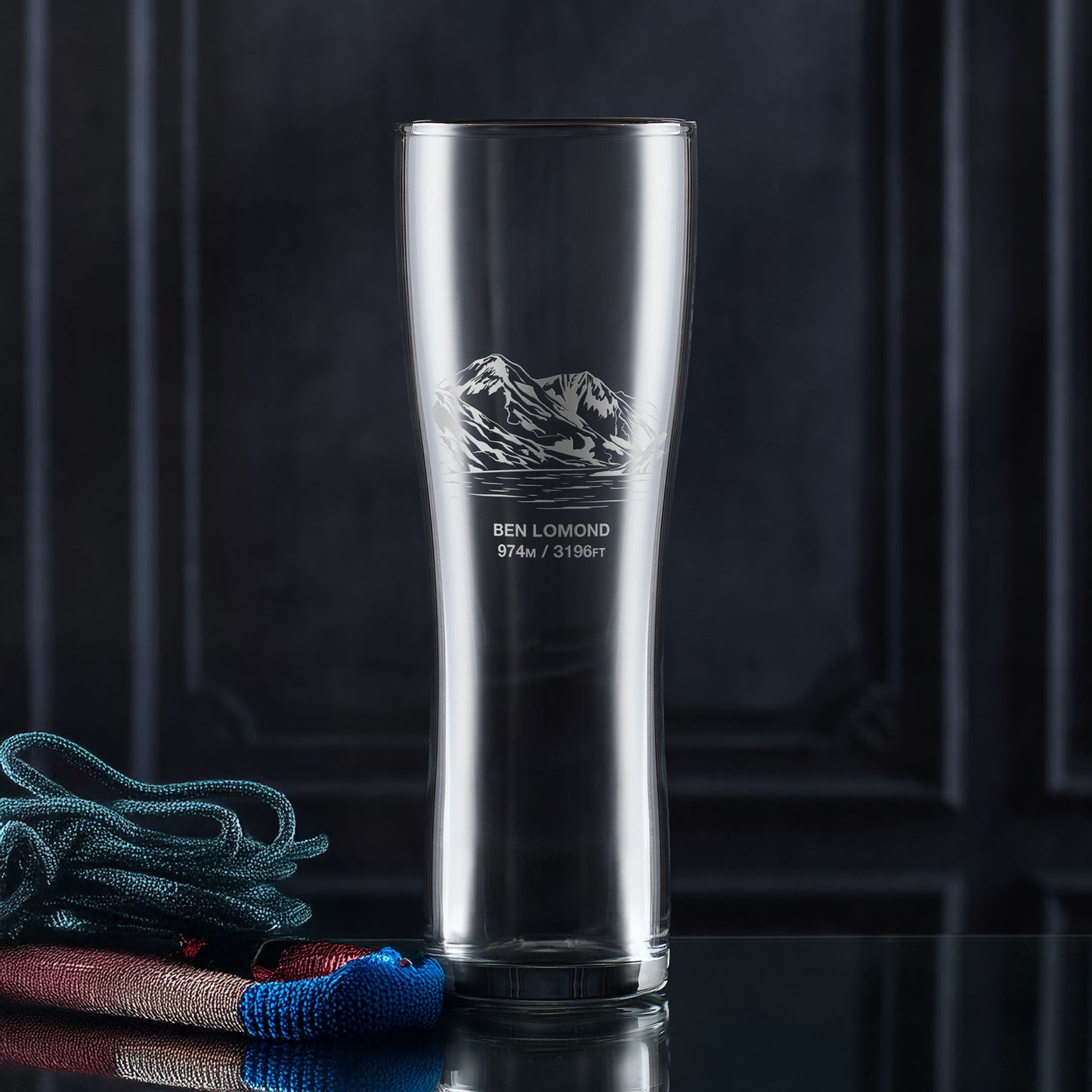 Tall pint glass with Ben Lomond mountain engraving on a dark background