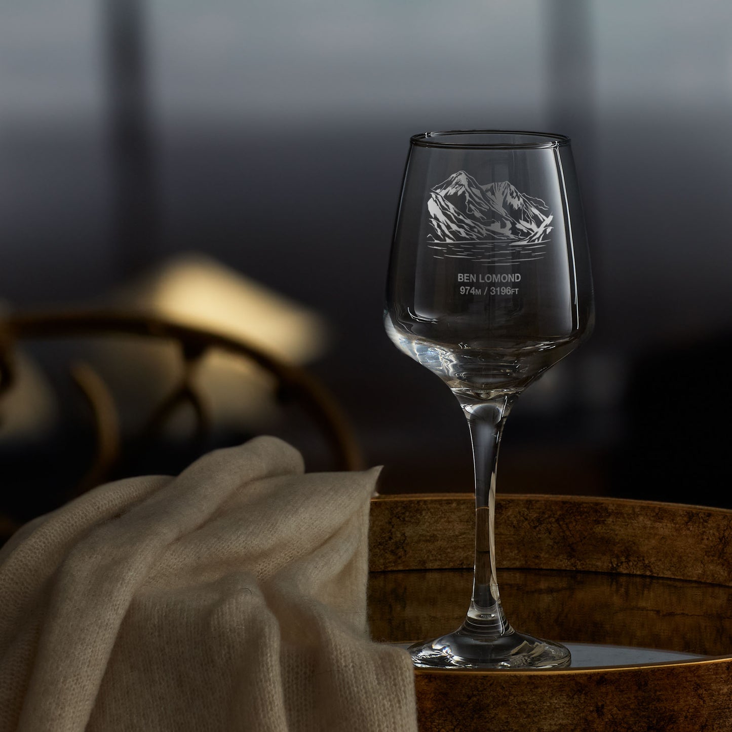 Wine glass engraved with Ben Lomond and its summit height, photographed on a wooden surface