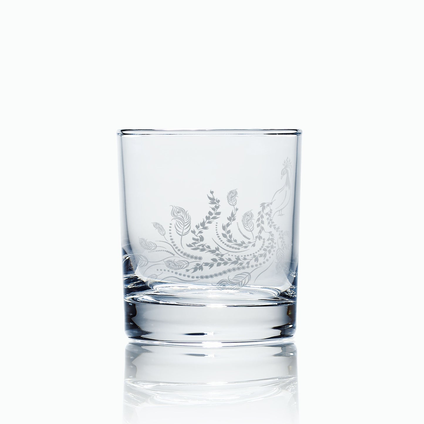 Front-view of engraved whisky glass showing the full peacock and leaf design inspired by Pittencrieff Park, photographed on a white background to highlight the glass form