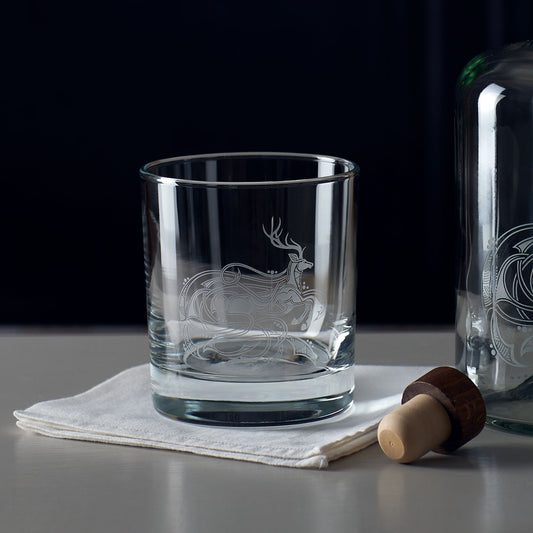 Stag whisky glass with engraved knotwork design on a dark background