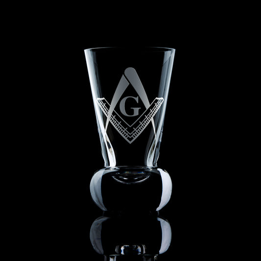 Masonic firing glass with a G and 2nd Degree Square & Compass engraving, shown on black background