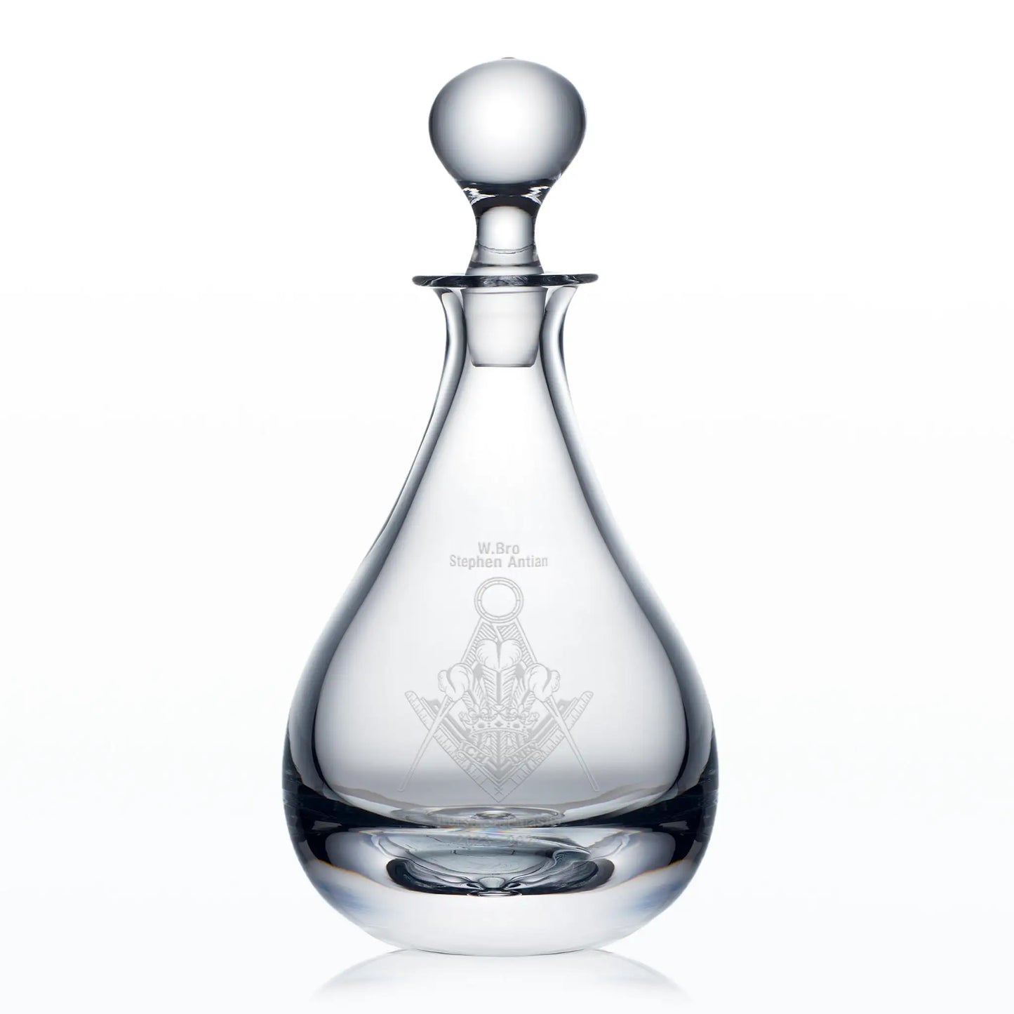 Clear glass decanter engraved Masonic lodge badge and spherical stopper on a white background