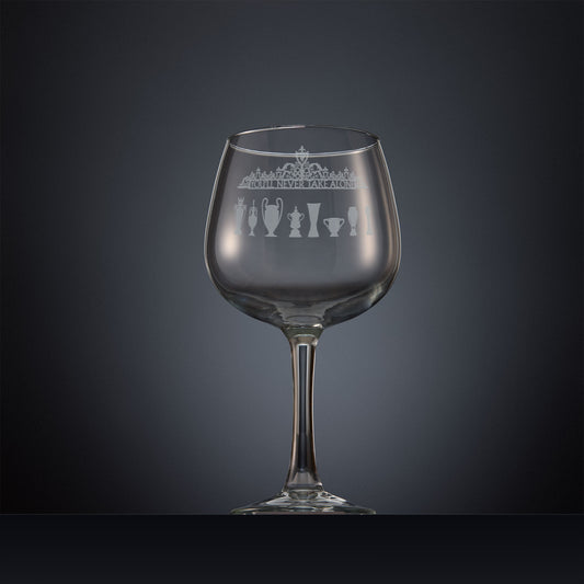Engraved gin glass featuring the Shankly Gates detail with trophy silhouettes, inspired by Anfield stadium and shown on a dark background