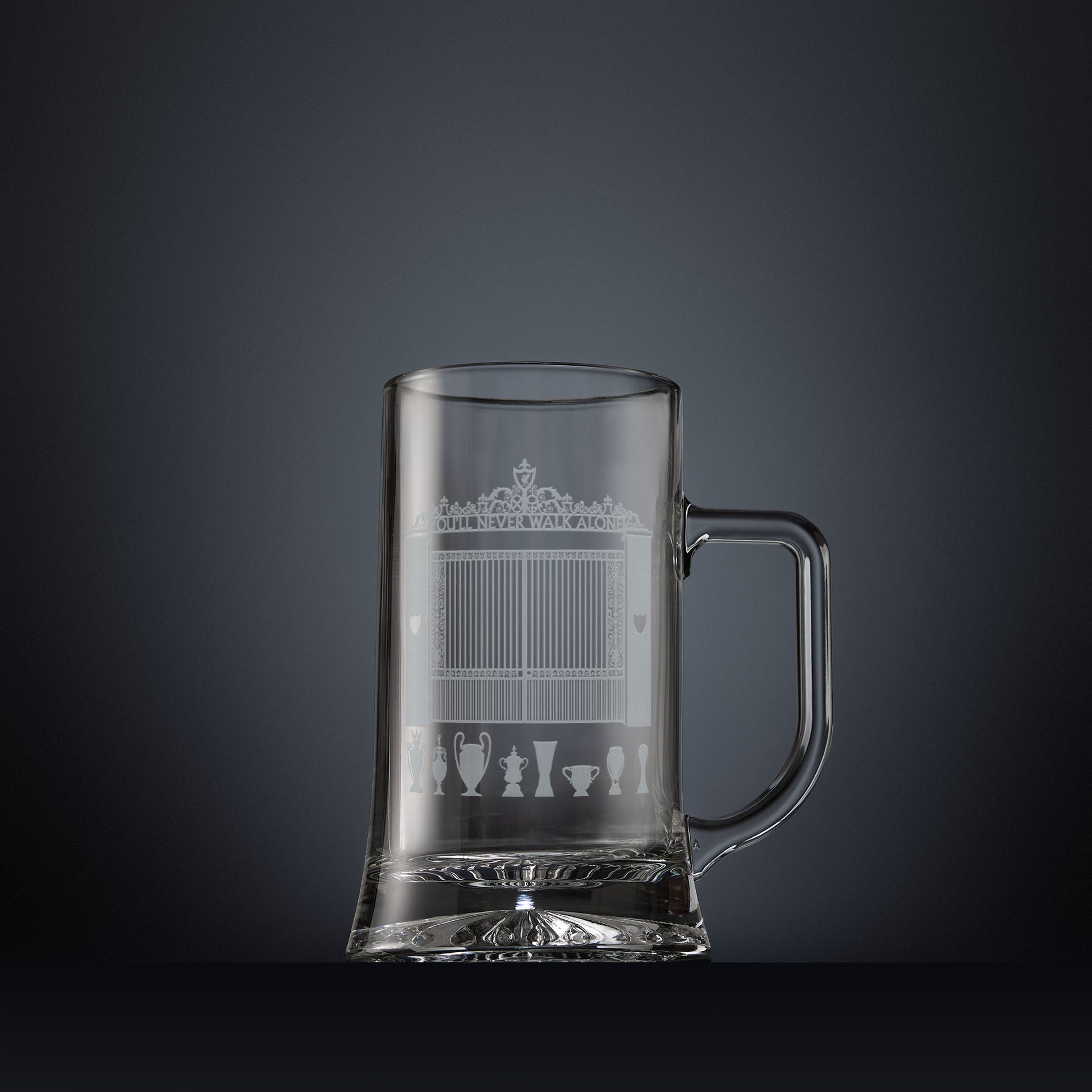Glass tankard engraved with a line-art interpretation of the Shankly Gates, with football trophy silhouettes beneath, inspired by the architectural details of Anfield Stadium.