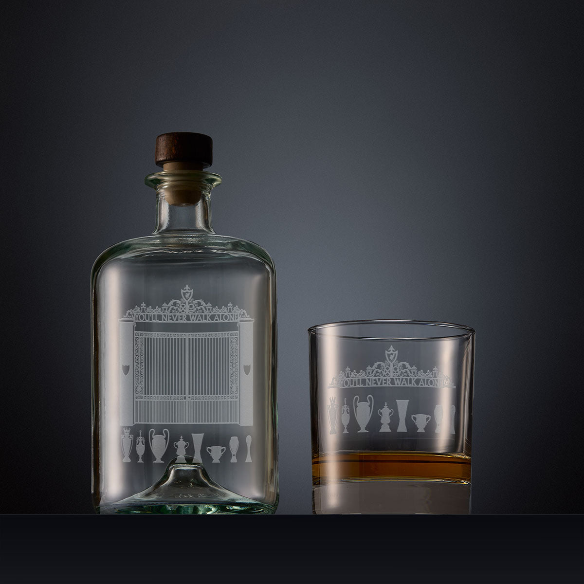 Engraved apothecary style decanter and whisky glass featuring a Shankly Gates inspired design, photographed on a dark studio background