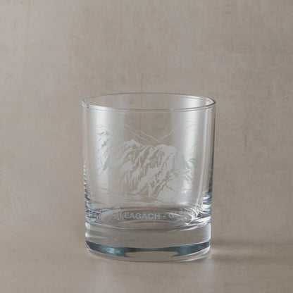 Engraved whisky glass with detailed image of the Aonach Eagah ridge, shown on a beige background