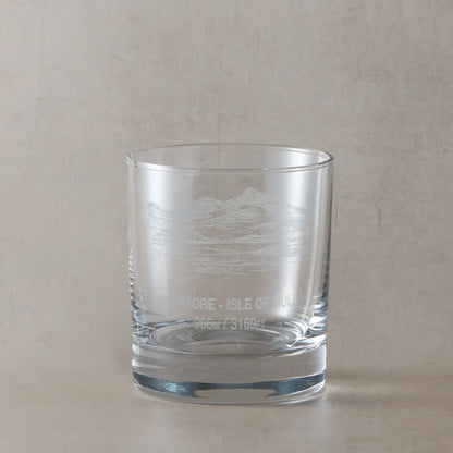 Whisky glass engraved with the Scottish mountain Ben More, styled on a beige background