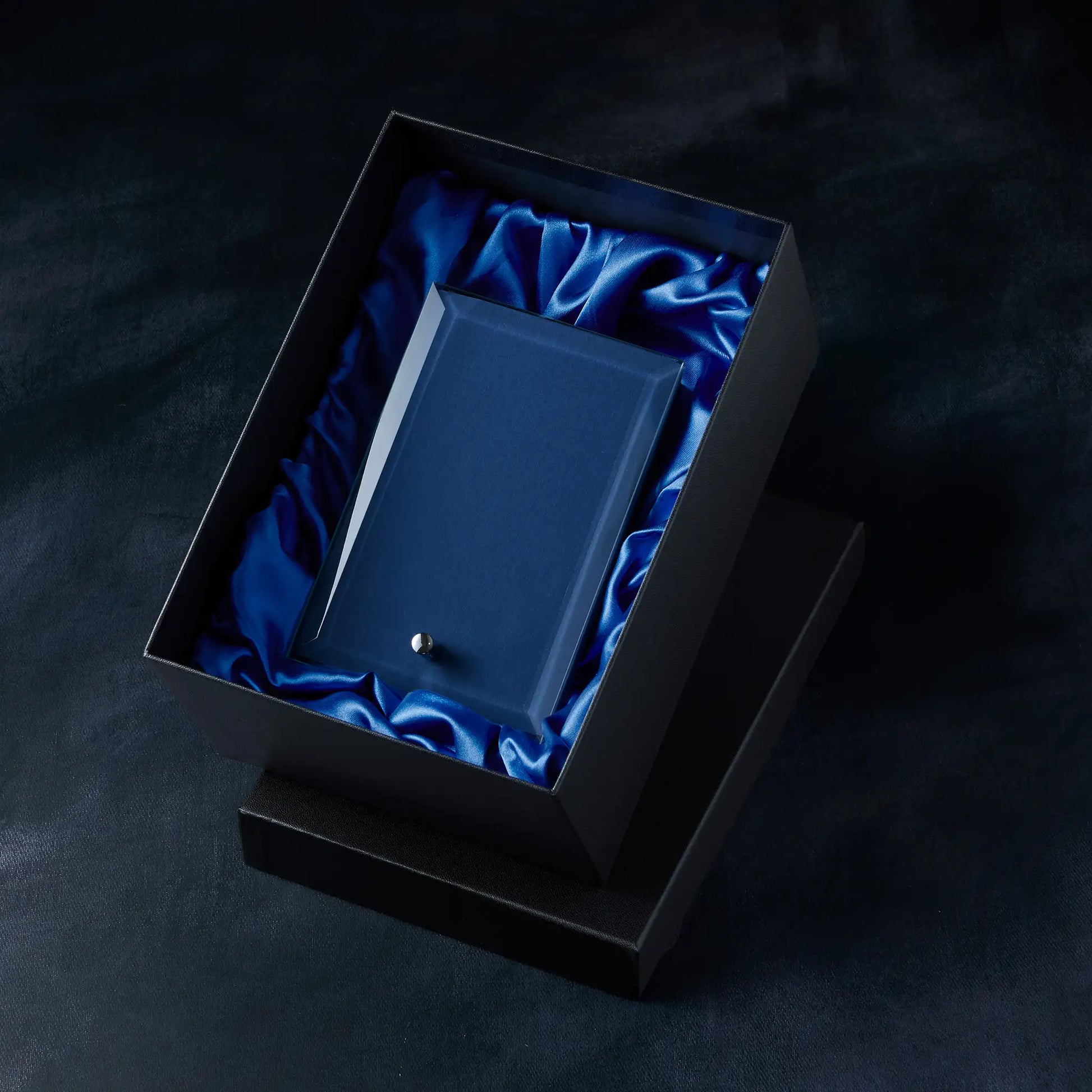Display plaque on blue satin fabric in a black box