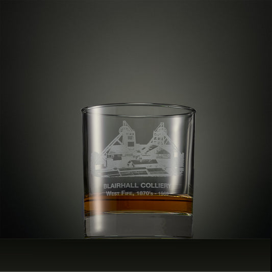 Clear glass tumbler with engraved coal mine design on a dark background