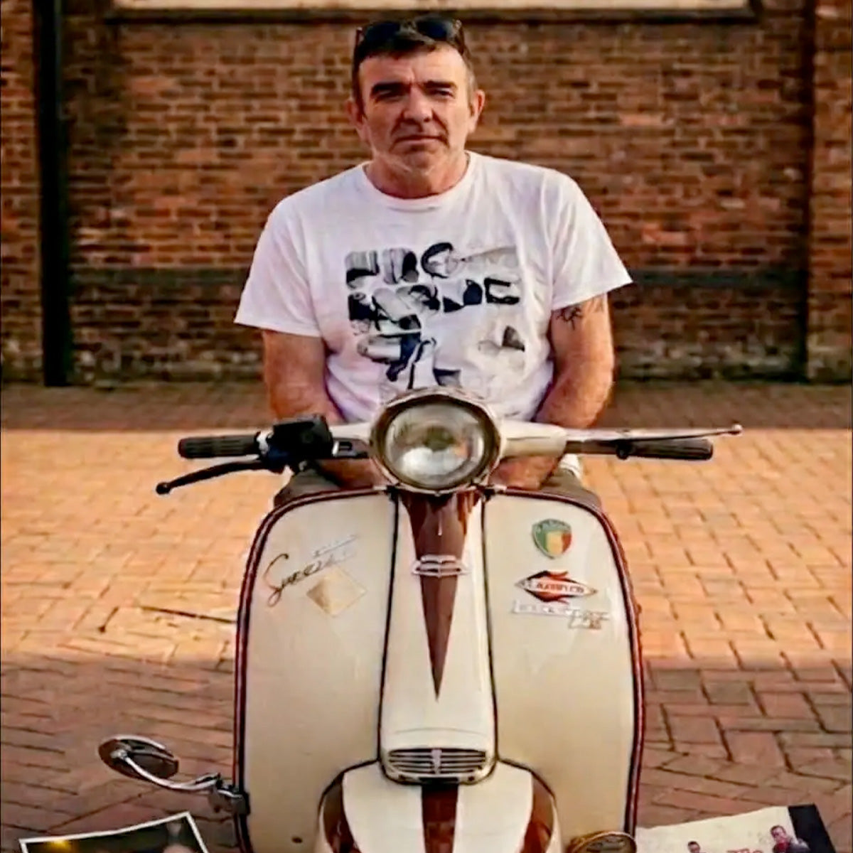 Photograph submitted for engraving of a man sitting on a vintage scooter.