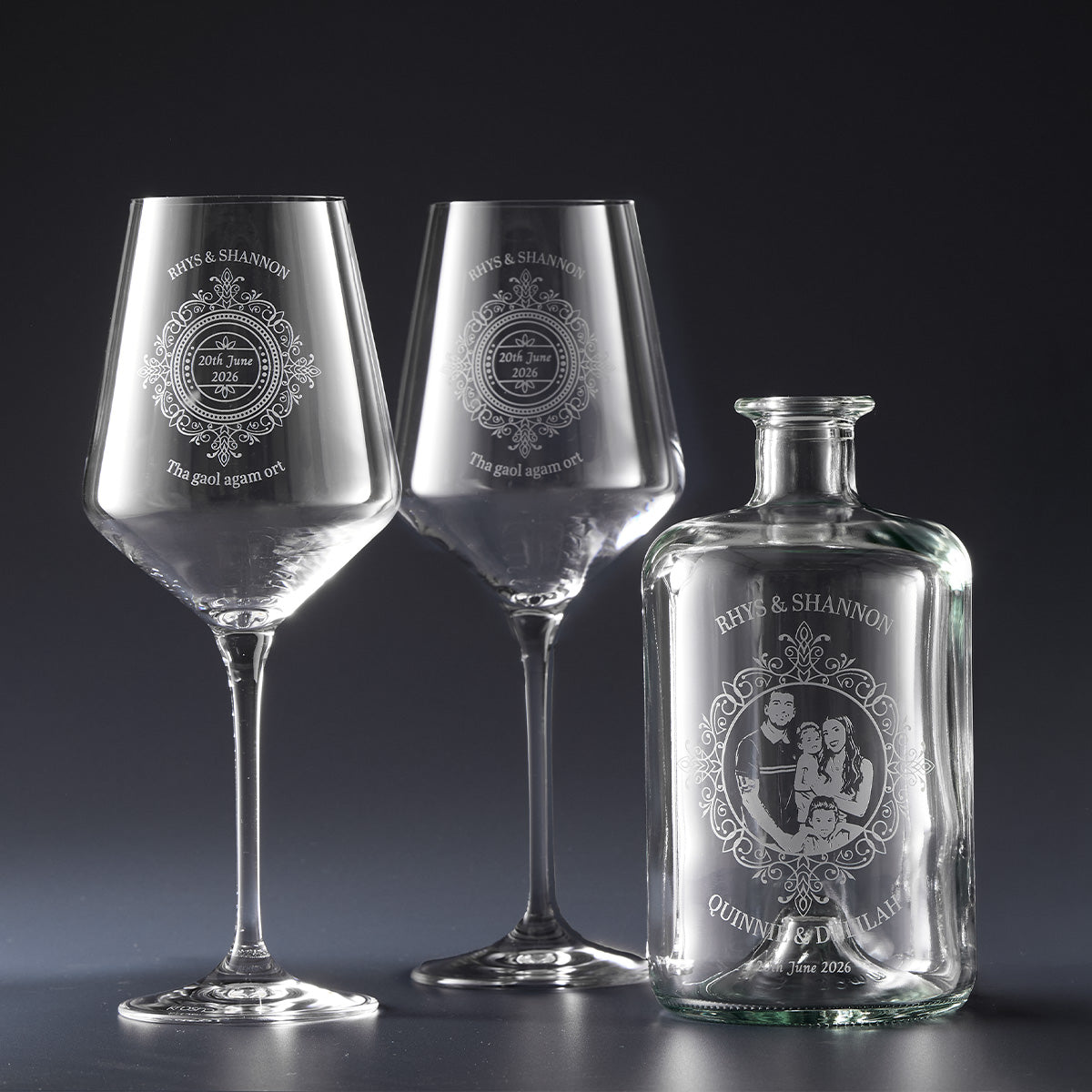 Two wine glasses and a decanter with engraved wedding designs and personalised text