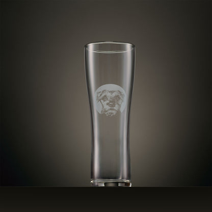 Engraved pint glass featuring a Border Terrier portrait set within a circular design, photographed on a dark studio background