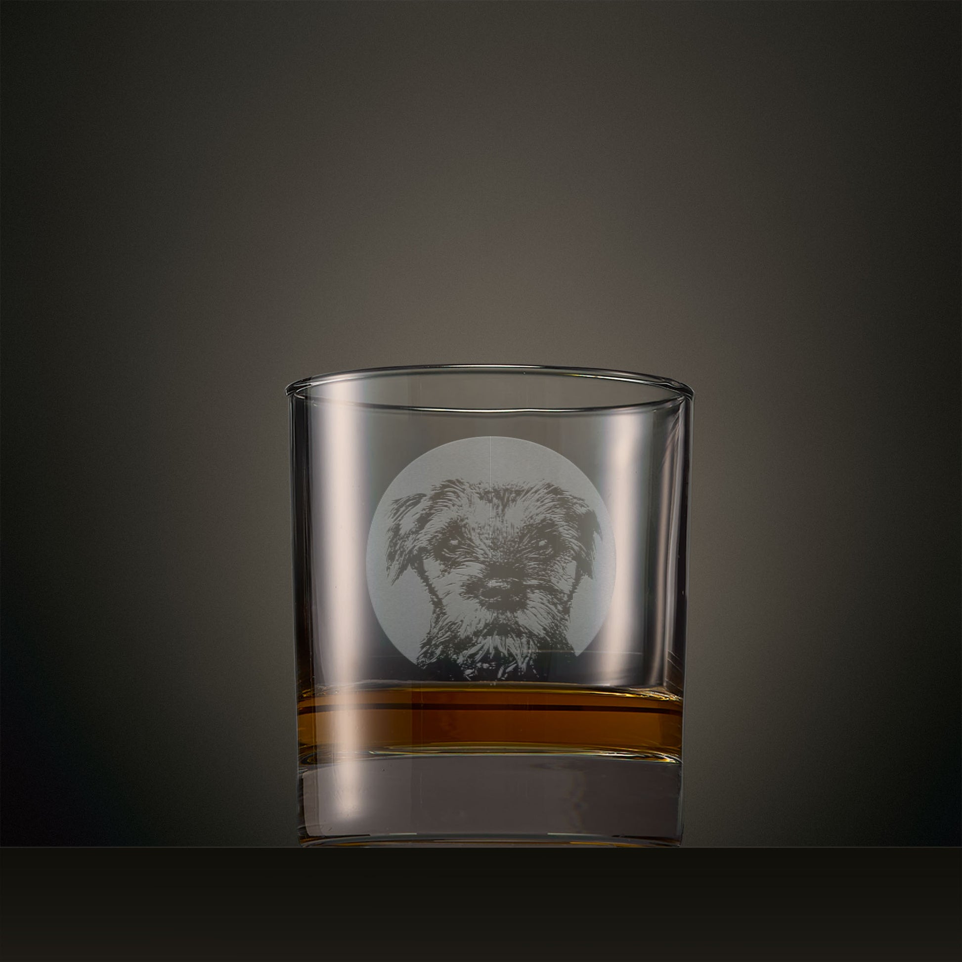 Engraved whisky glass featuring a Border Terrier portrait set within a circular design, photographed on a studio background