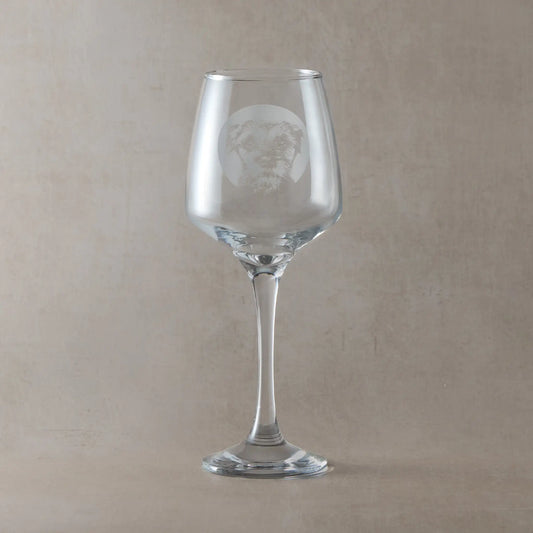 Wine glass with engraved with portrait of a Border Terrier in circular frame , photographed in a pale background