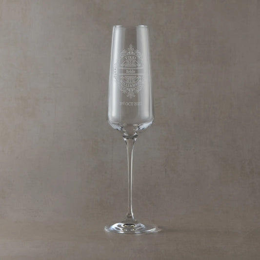 Engraved champagne flute with  Brides Name and wedding date, surrounded by a venetian lace design on a beige background