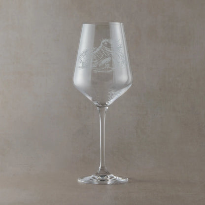 Engraved wine glass featuring the Cailleach, a mythic figure of winter and mountains, etched into clear glass and photographed on a soft neutral background