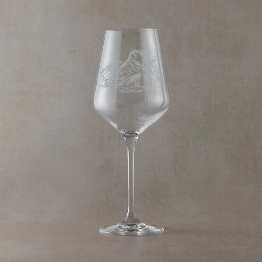 Engraved wine glass featuring the Cailleach, a mythic figure of winter and mountains, etched into clear glass and photographed on a soft neutral background
