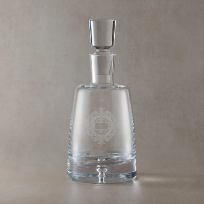 Clear glass decanter with engraved wedding anniversary design on a beige background