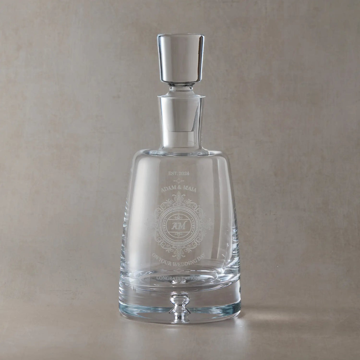 Handmade glass spirit decanter with engraved wedding lace design on a beige background