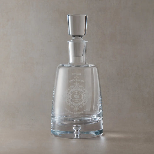 Handmade glass spirit decanter with engraved wedding lace design on a beige background
