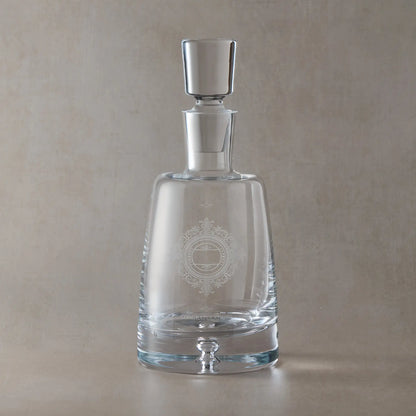 Clear glass decanter with engraved Chantilly Lace design on a beige background