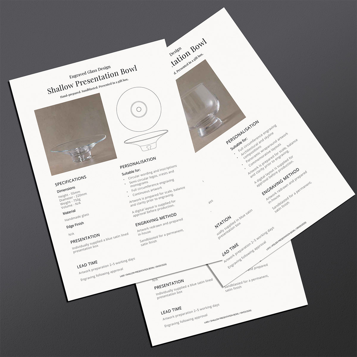 Two brochures detailing specifications and features of engraved glass bowls on a dark surface.