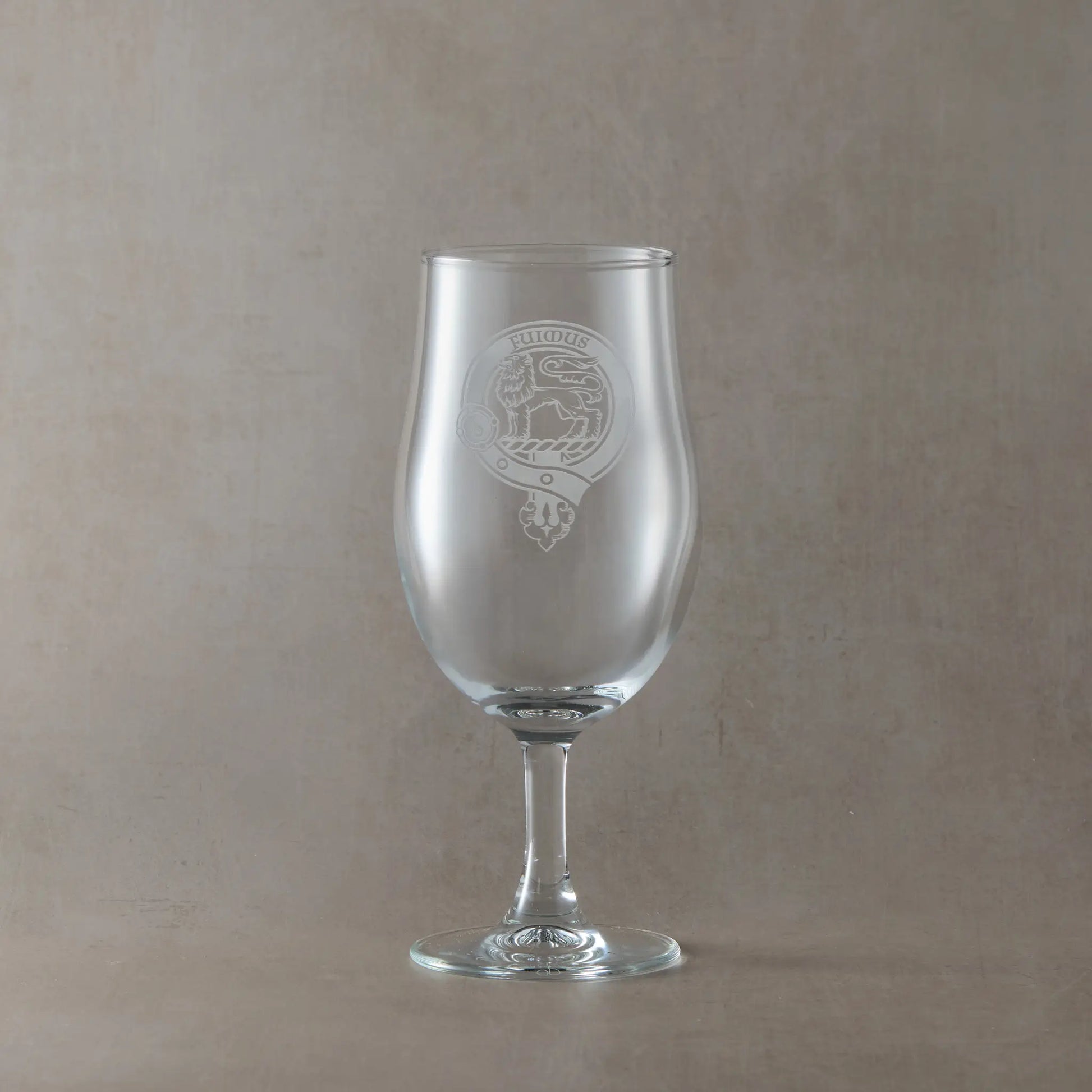 Engraved stemmed beer glass with an  illustration of a Scottish clan crest with belt and buckle