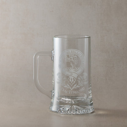 Clear glass tankard with engraved Scottish Clan Crest design and motto on a beige background
