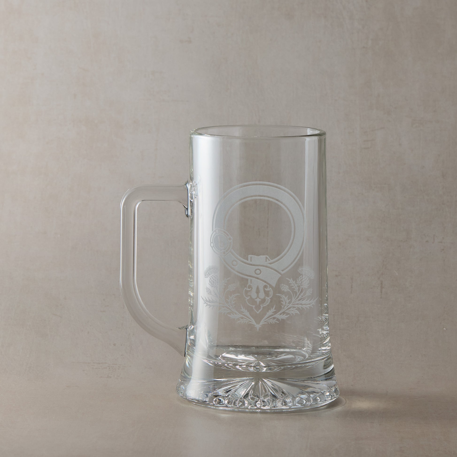 Clear glass tankard with engraved Scottish Clan Crest buckle and thistles with handle on the left