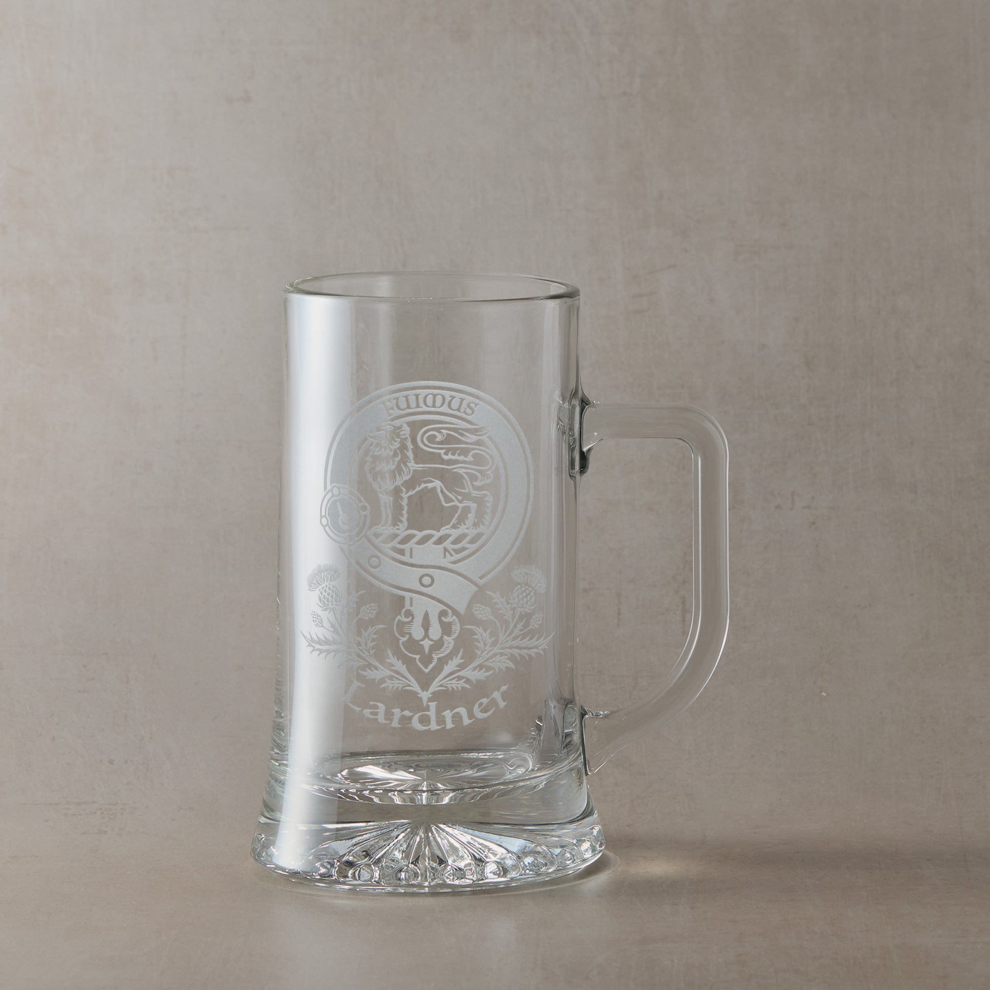 Clear glass tankard with engraved Scottish Clan Crest design and motto with handle on right