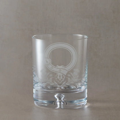 Whisky glass with intricate thistle and Scottish buckle design on a beige background