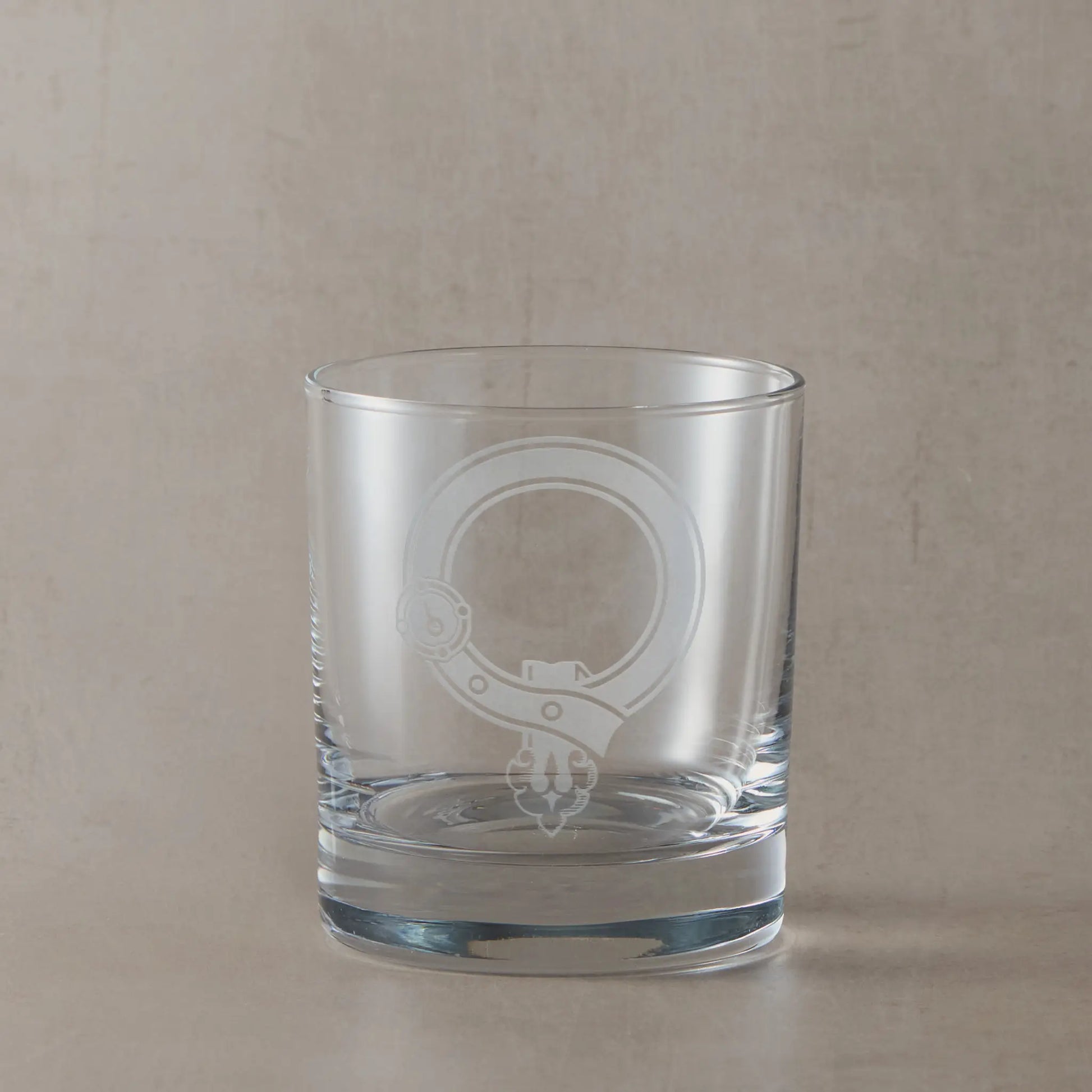 Engraved whisky glass featuring a Scottish clan crest with belt and buckle motif, centre left blank for your own design