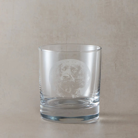 Whiskey glass with engraved working cocker spaniel portrait, on a beige background