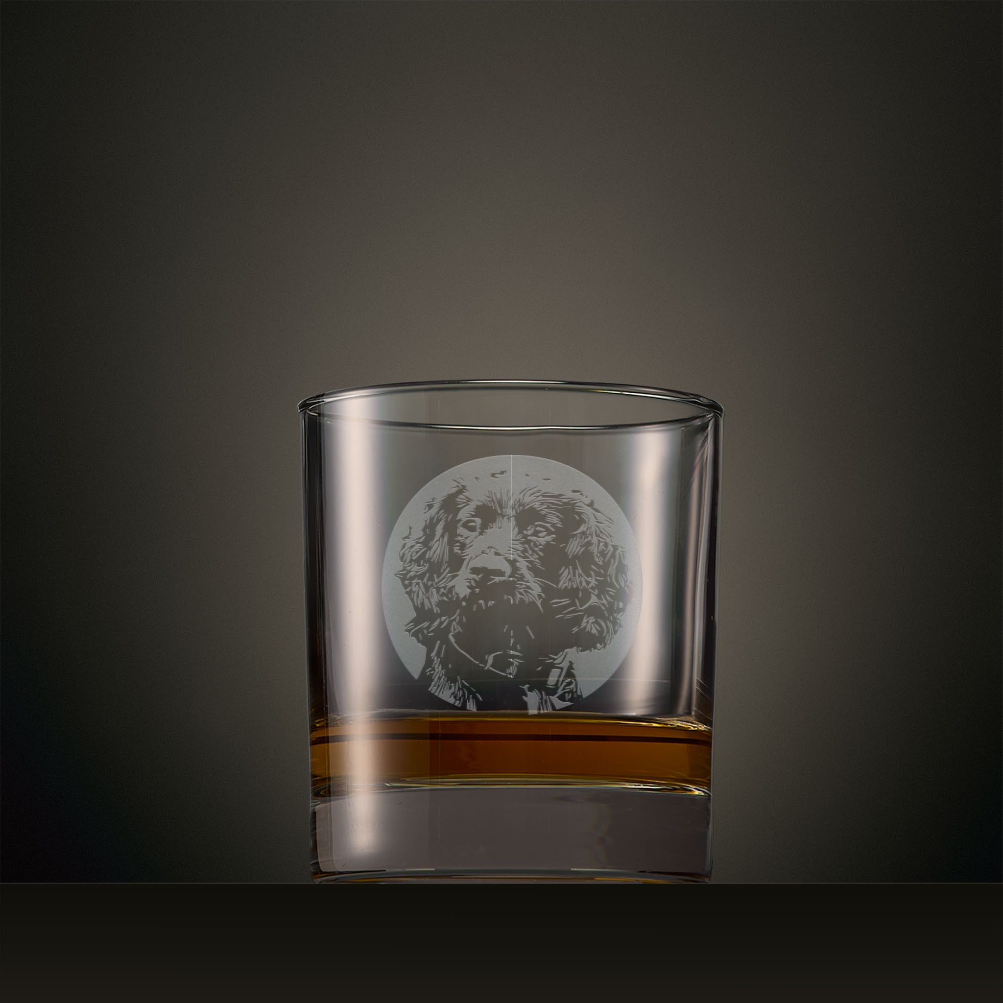 Engraved whisky glass featuring a Cocker Spaniel portrait set within a circular design, photographed on a studio background