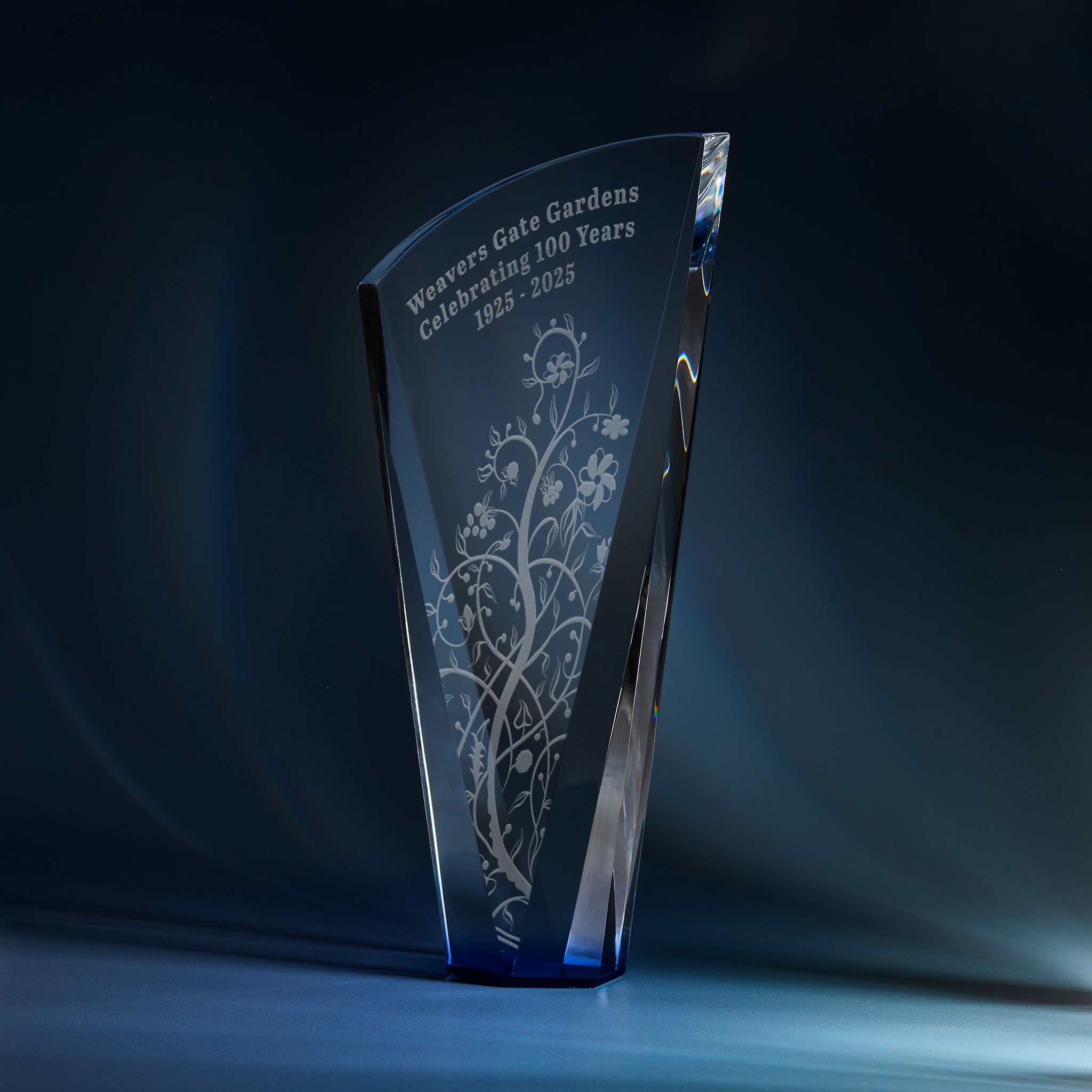 Engraved optical crystal shard award with sapphire blue base and corporate logo