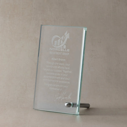 Custom corporate glass rectangle award with engraved text and logo on a beige background